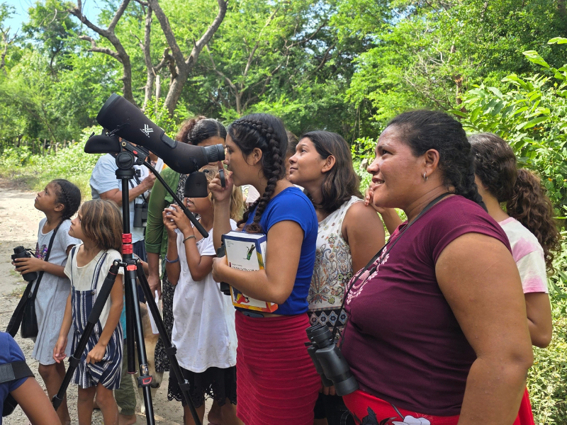 Mujeres y niñas participan en una jornada de observación de aves.