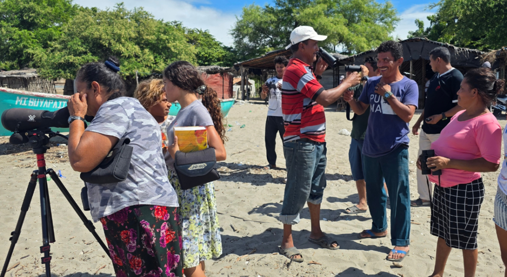 Women and men fishers take part in a birdwatching session.